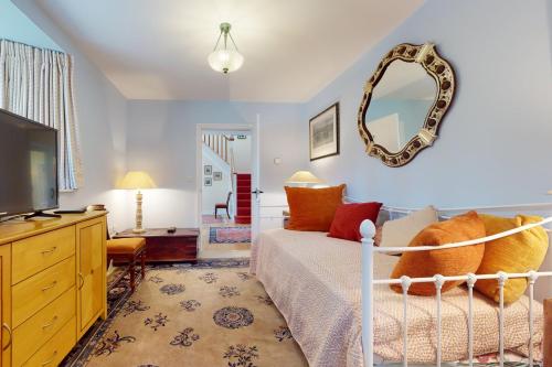 a bedroom with a bed and a mirror on the wall at The Wool Barn Simonsbath in Exford
