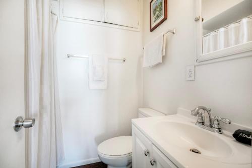 a white bathroom with a toilet and a sink at Oceanfront Condo, Private Patio, Beach Access, BBQ in Carlsbad