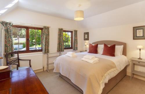 a bedroom with a large bed with two towels on it at Pebble Cottage Dunster in Dunster