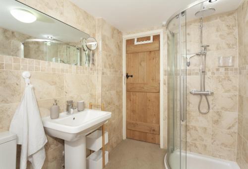 a bathroom with a sink and a shower at Pebble Cottage Dunster in Dunster