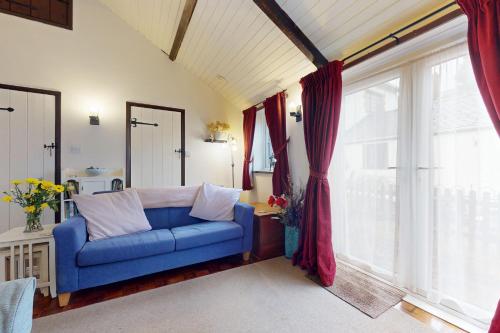 a blue couch in a room with a large window at Sheepfold Cottage Dulverton in Dulverton