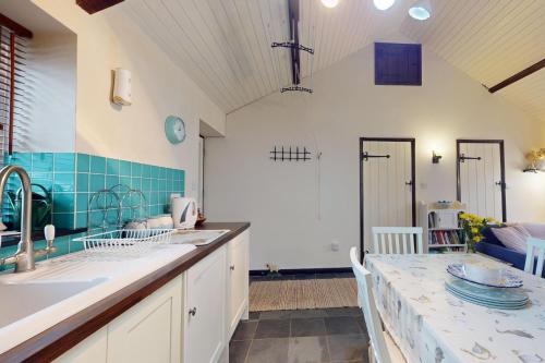 a kitchen with white cabinets and a counter top at Sheepfold Cottage Dulverton in Dulverton