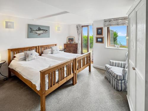 a bedroom with two beds and a window at St Anthonys Cottage Porlock Weir in Porlock
