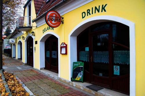a yellow building with a drink sign on it at Delanta Panzio in Pécs