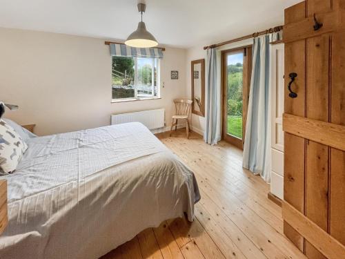 a bedroom with a bed and a large window at Ormrods Withypool in Withypool