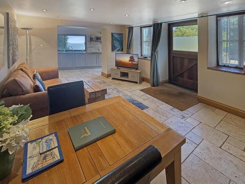 a living room with a couch and a table at The Coach House Porlock Weir in Porlock