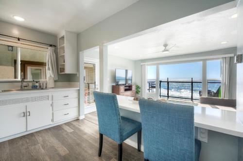a kitchen with a table and chairs with a view of the ocean at Oceanfront Apartment, Private Balcony, Beach Access, Sunset Views in Carlsbad