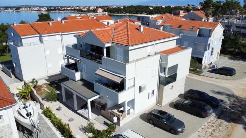 an aerial view of a house with cars parked in front at Spacious 3 Bedroom Apartment 50m from Sea 2 Bathrooms 2 Terraces Near Beach in Privlaka