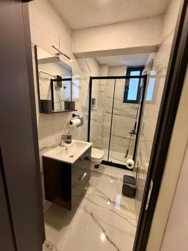 a white bathroom with a sink and a shower at MEYS Apartment 2 in Istanbul