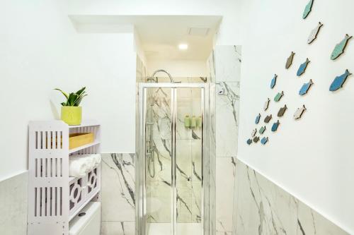 a bathroom with a shower with marble walls at Kai Loft & Suite - By the Sea in Giardini Naxos