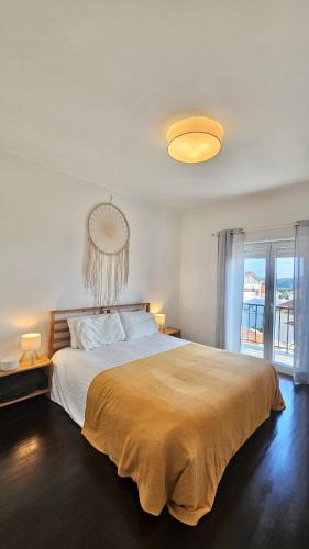 a bedroom with a large bed and a large window at Yellow House Ericeira in Santo Isidoro