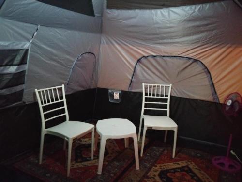 two chairs and a table in a tent at Bacalar Inn Hotel & Glamping Bacalar in Bacalar