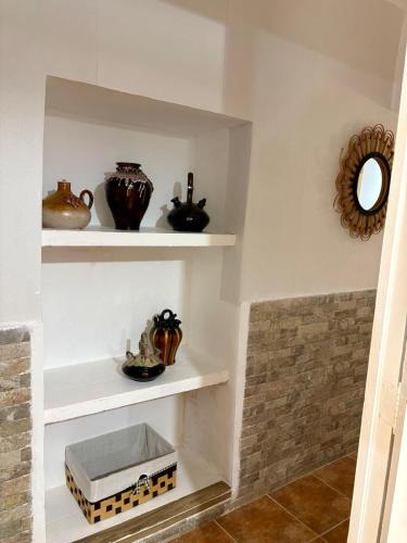 a room with white shelves with vases and a mirror at Chalet Eucaliptus in Alcossebre