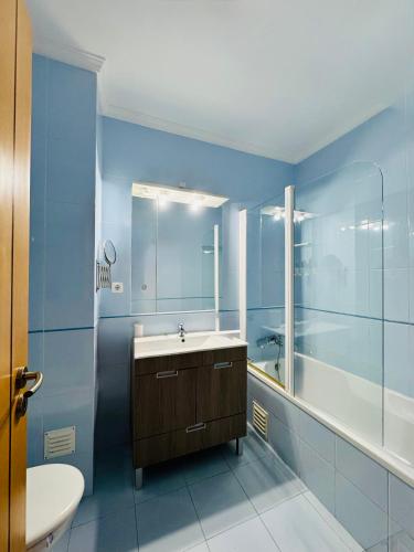 a blue bathroom with a sink and a shower at Renaissance Sunrise Inn Algarve in Portimão