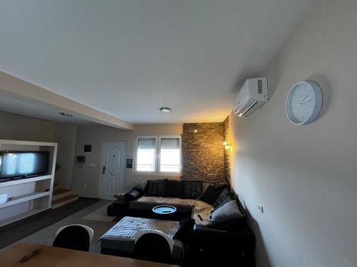 a living room with a couch and a clock on the wall at Blue River, sojenica na Dunavu in Belgrade