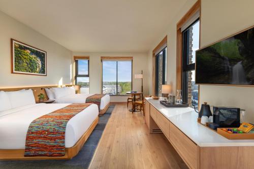 a hotel room with two beds and a flat screen tv at The Compton in Bentonville