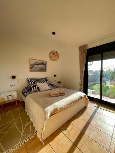 a bedroom with a large bed and a large window at El Nido del Sol in La Oliva