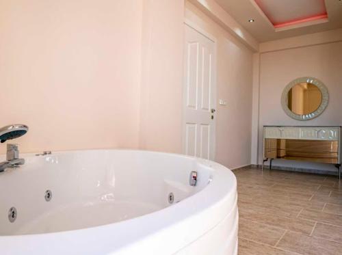 a large white tub in a bathroom with a mirror at Villa adelina in Çavdır