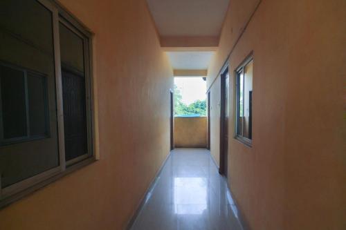 an empty hallway with two windows in a building at Hotel O by OYO Kb Residency in Kurinjippādi