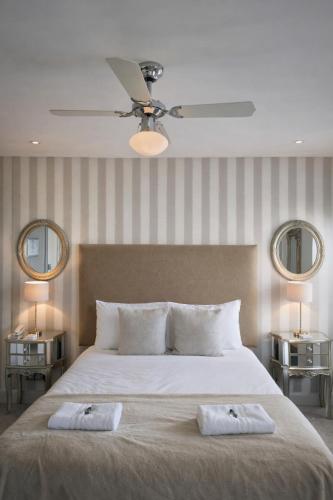 a bedroom with a large bed with two mirrors at Crescent Victoria Hotel in Margate