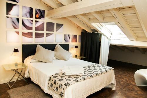 a bedroom with a large white bed and a table at Abadía San Martín in San Martín del Castañar