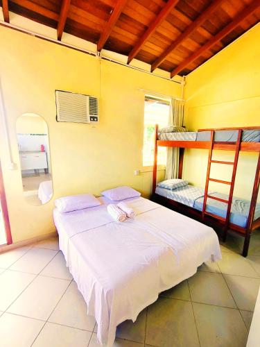 a bedroom with a bed and two bunk beds at Trindade Hospeda - Stúdios e Suítes privativos Vila Trindade in Trindade