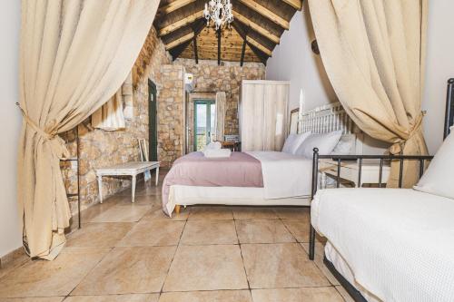 a bedroom with two beds and a stone wall at GAIA - Boutique Retreat in Marathopoli