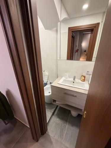 a bathroom with a sink and a toilet and a mirror at Il Nido della Regina - 250m dal Lago di Bolsena in Marta