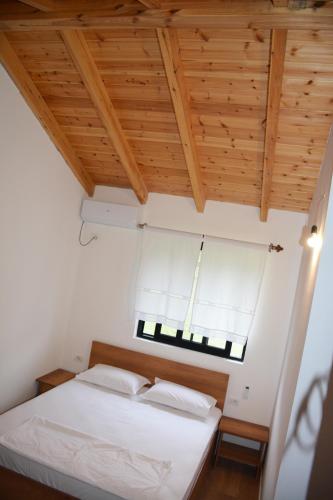 a bedroom with a white bed and a window at Ferma Hodobashi in Çerenisht