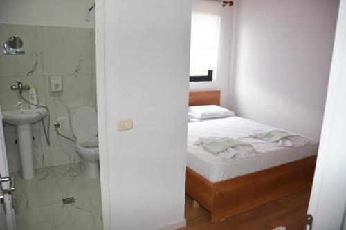 a bedroom with a bed and a shower and a toilet at Ferma Hodobashi in Çerenisht