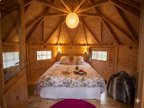 a bedroom with a bed in a wooden cabin at La Roche aux Fées in Lapte