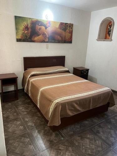 a bedroom with a large bed with two tables at Casa Brusodia in Guadalajara