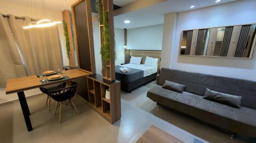 a living room with a couch and a bed at Studio 48 - Lindo apto Studio no centro de Foz in Foz do Iguaçu