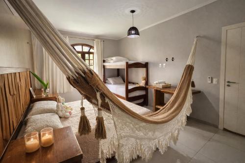 a bedroom with a hammock in a room with a bed at Chalé De Canoa in Aracati