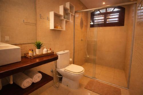 a bathroom with a shower and a toilet and a sink at Chalé De Canoa in Aracati