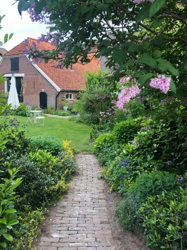 a brick path through a garden with flowers at B&B Chez Nous in Geesteren