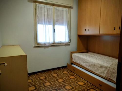 ein kleines Zimmer mit einem Bett und einem Fenster in der Unterkunft Volano in Lido di Volano