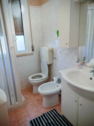 ein Badezimmer mit Toilette und Waschbecken in der Unterkunft Volano in Lido di Volano