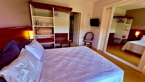 a bedroom with a large bed and a room with a bed sqor at Suite master, condo-hotel in Joinville