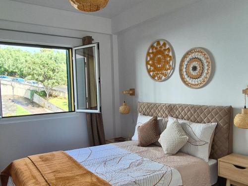 a bedroom with a bed and a large window at Spacious Bright Apartament with Ocean Views in Caniço