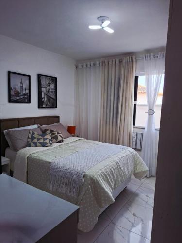 a bedroom with a bed and a window at Aconchego em Maricá in Maricá