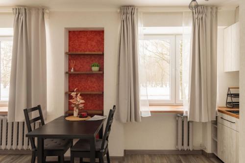 a kitchen and dining room with a table and a window at Park-View Studio Apartment with Free Parking - 10 min to Old Town in Riga