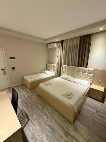 a hotel room with two beds and a window at Hotel Lungomare in Vlorë