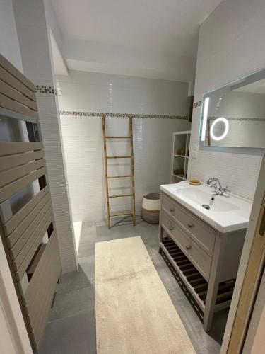 a bathroom with a sink and a toilet and a mirror at L'escapade Saint Michel in Val Couesnon