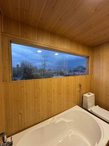 a bathroom with a bath tub and a window at Weather cottage in Srinagar
