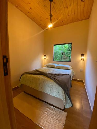 a bedroom with a bed and a window at Casa Araucária in Cunha