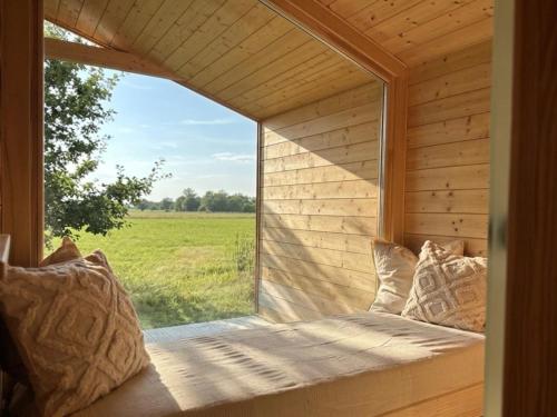 a window in a room with a view of a field at 101 Tiny House Elbhütte mit Wiesenblick in Bleckede