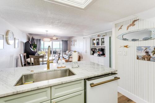 a kitchen with a sink and a dining room at Beachfront! Indian Rocks Beach Condo w/ Balcony in Clearwater Beach