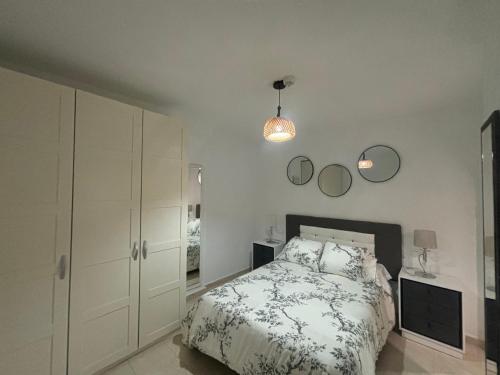 a bedroom with a bed and two mirrors on the wall at Apartamentos Amy 5 in Huelva