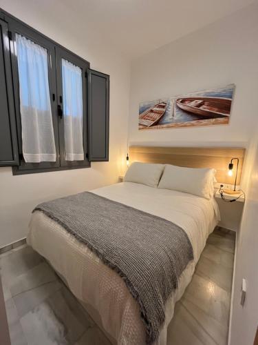 a bedroom with a bed and two windows at Casa Palacio Caballeros in Sanlúcar de Barrameda